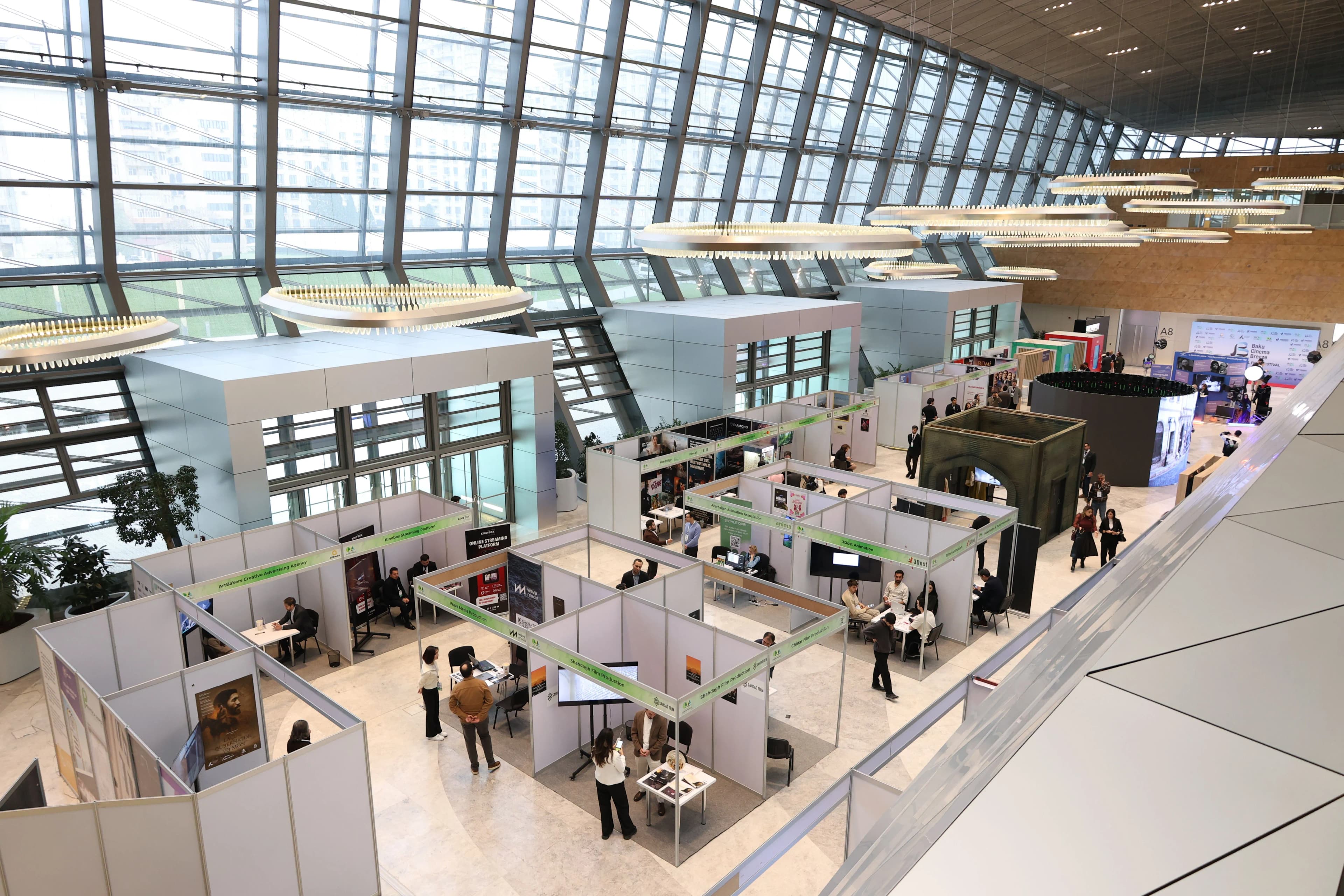 Exhibition hall with branded booths and visitors during a live activation.