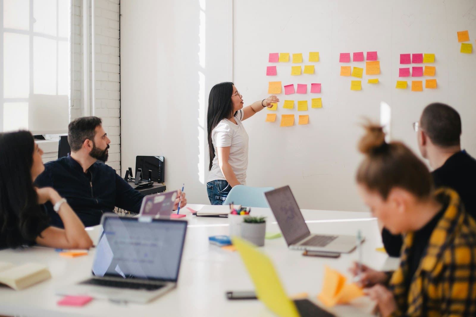 A team planning a campaign around a table and a wall of notes.
