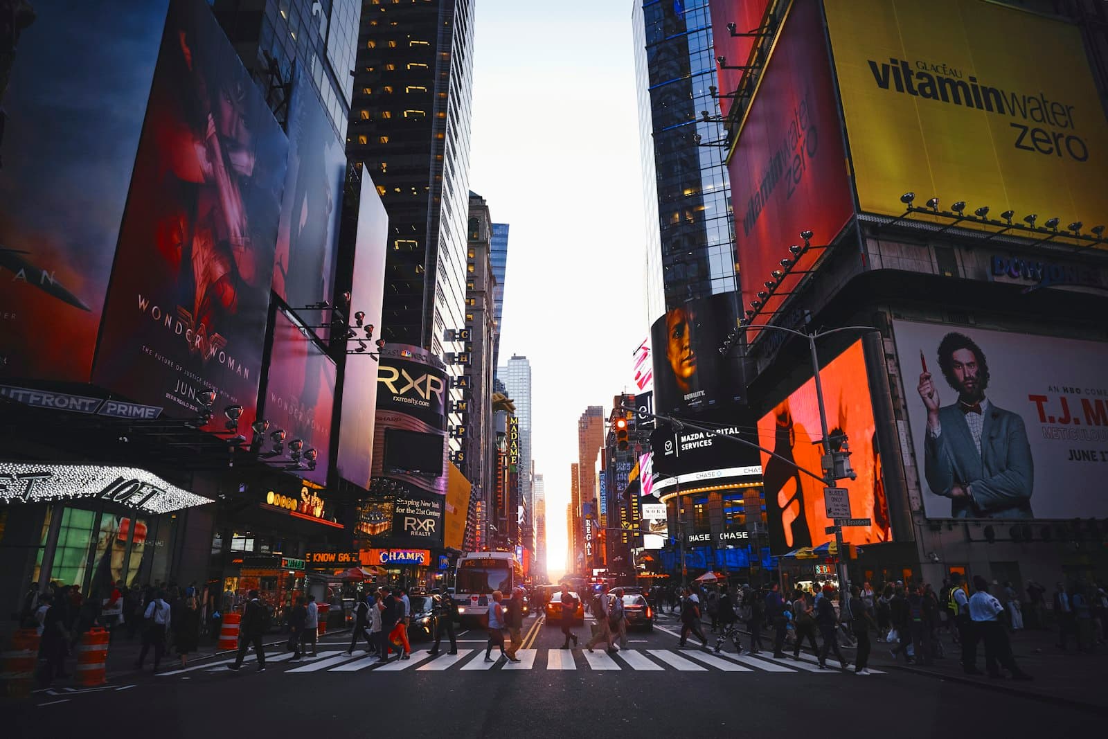 City street lined with large outdoor billboards and illuminated brand displays.