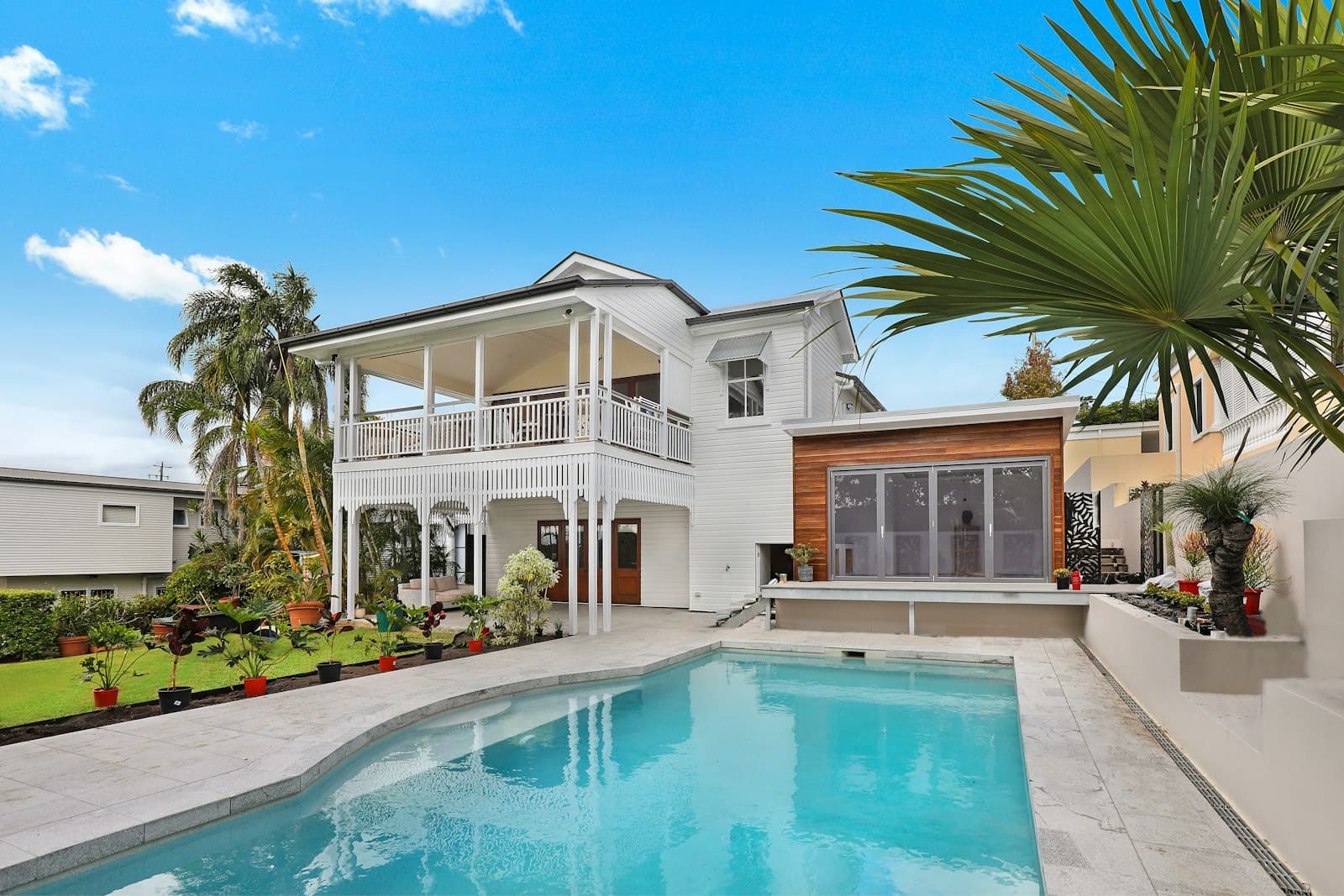 A residential house with a garden and pool, photographed for a property listing.