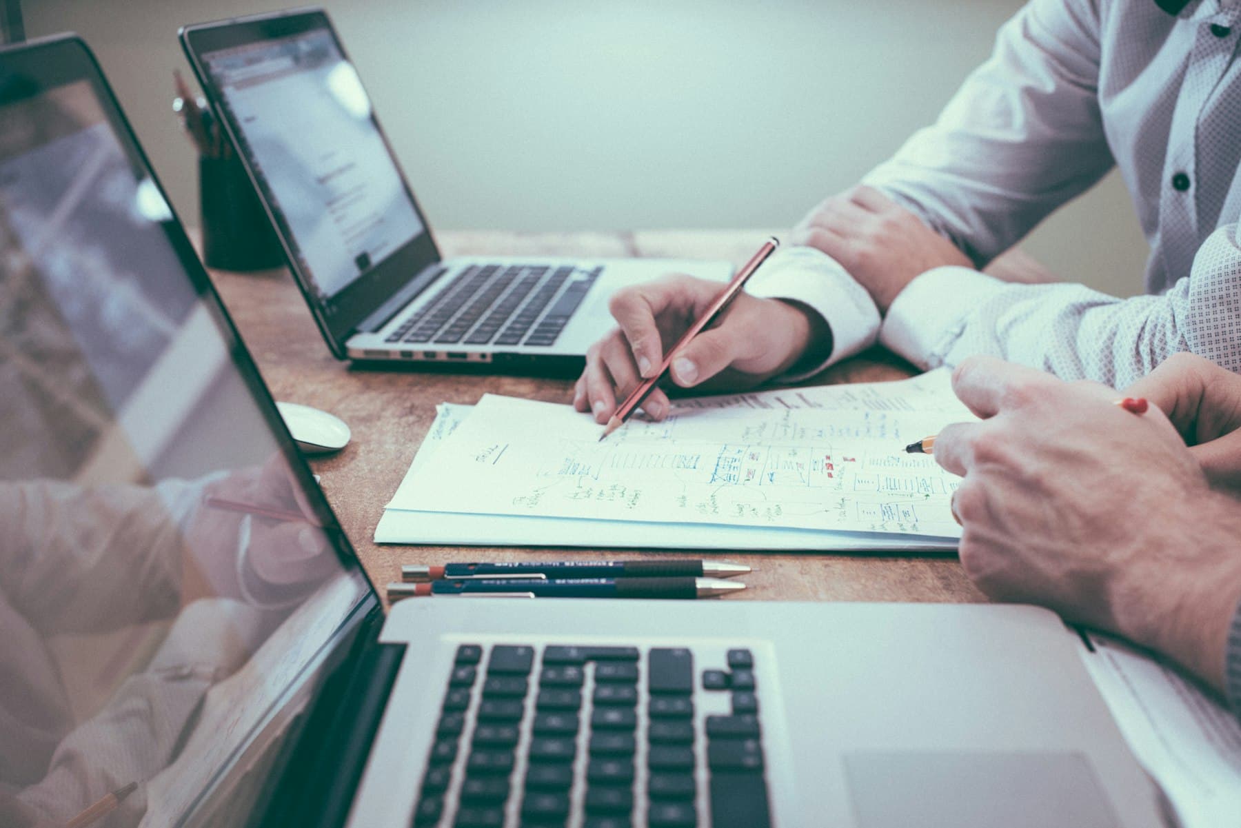 Recruiters planning a hiring process with notes and laptops.